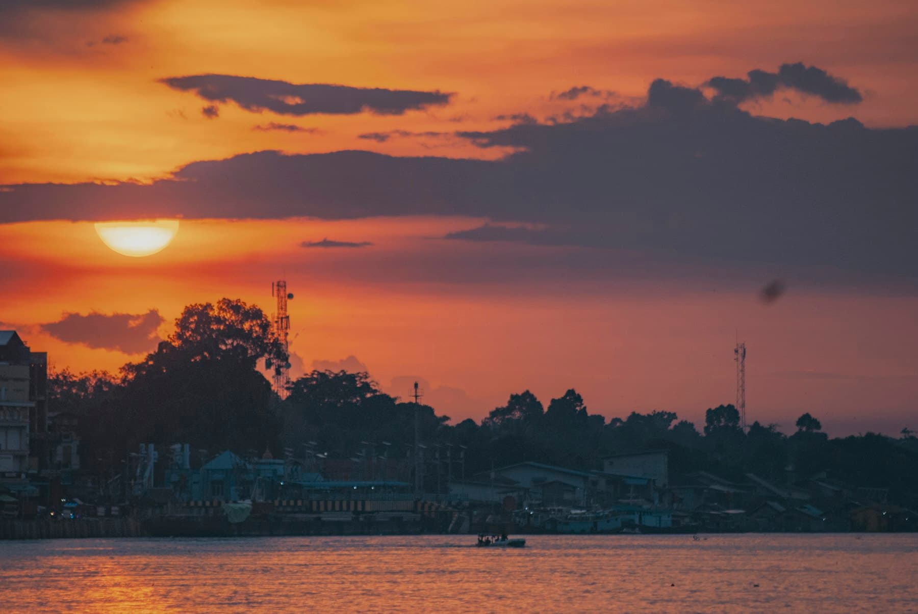 Matahari terbenam keemasan di atas sungai