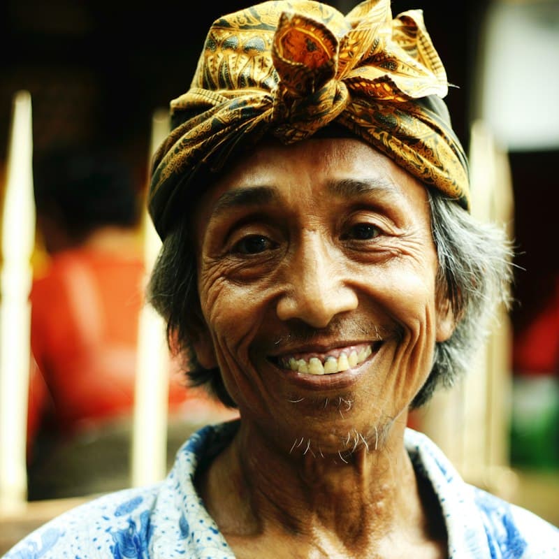 Potret Pak Yusran tersenyum mengenakan ikat kepala batik